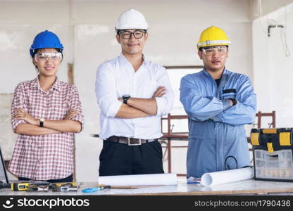 Construction engineer teamwork Safety Suit Trust Team Holding White Yellow Safety hard hat Security Equipment on Construction Site. Hardhat Protect Head for Civil Construction Engineer Concept