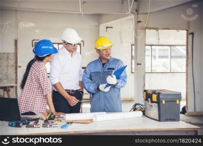 Construction engineer teamwork Safety Suit Trust Team Holding White Yellow Safety hard hat Security Equipment on Construction Site. Hardhat Protect Head for Civil Construction Engineer Concept