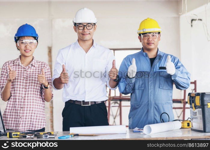 Construction engineer teamwork Safety Suit Trust Team Holding White Yellow Safety hard hat Security Equipment on Construction Site. Hardhat Protect Head for Civil Construction Engineer Concept