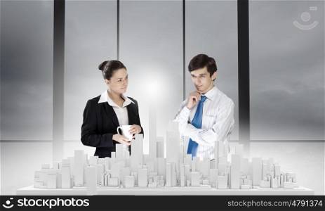 Construction engineering. Two business people examining design of construction model