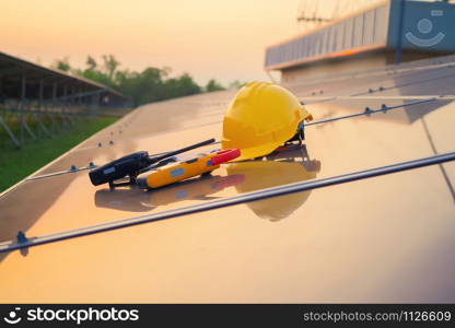 Construction equipment tools with solar panels or solar cells on the roof in farm. Power plant with green field, renewable energy source in Thailand. Eco technology for electric power at sunset.