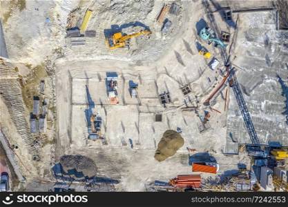 Construction equipment working at the construction site. Aerial view from drone