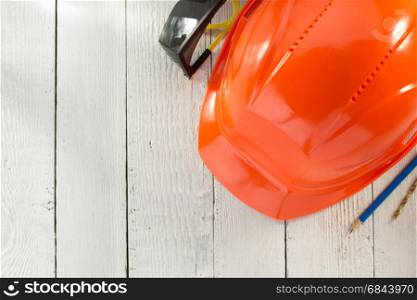 construction helmet and safety glasses on wood. construction helmet and safety glasses on wooden background