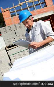 Construction manager using electronic tablet on building site