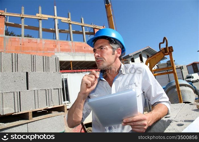 Construction manager using electronic tablet on building site