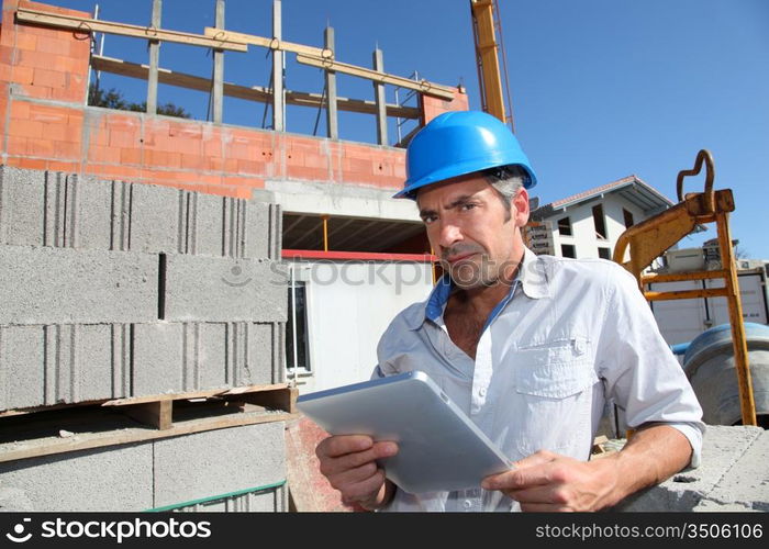 Construction manager using electronic tablet on building site