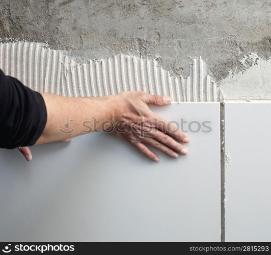 construction mason man hands on tiles work with notched trowel cement mortar