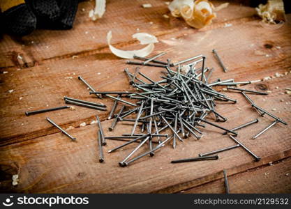 Construction nails on the table. On a wooden background. High quality photo. Construction nails on the table.