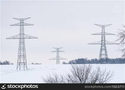 Construction of high voltage pylons in winter. Assembled power transmission line supports, ready for installation.