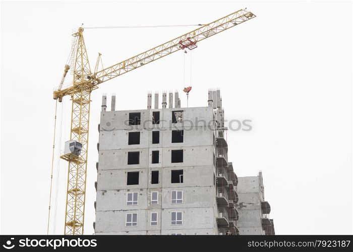 construction of multi-storey building with a crane. Unfinished house with a crane on construction site
