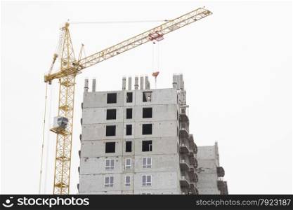construction of multi-storey building with a crane. Unfinished house with a crane on construction site