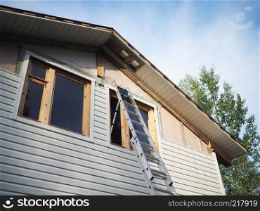 Construction of the frame house. Siding installation