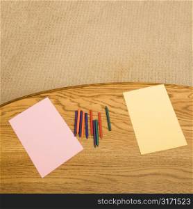 Construction paper and crayons on table.