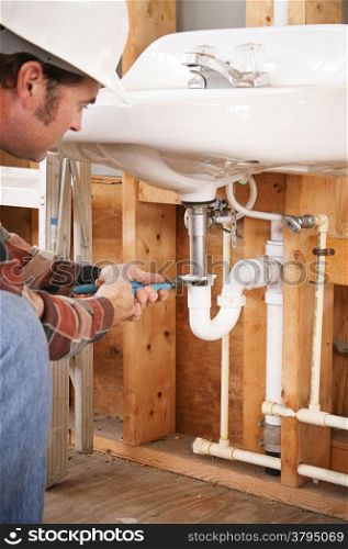 Construction plumber instaling a sink in a new building or renovation.