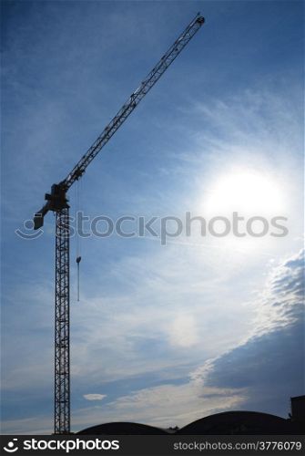 Construction site building hoisting crane on evening sky background
