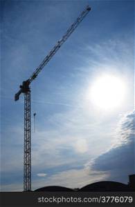 Construction site building hoisting crane on evening sky background