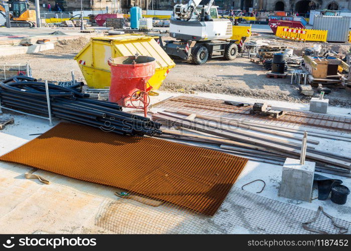 Construction site in the middle of the old european city. Concrete mixer and reinforcement mesh in downtown, building engineering