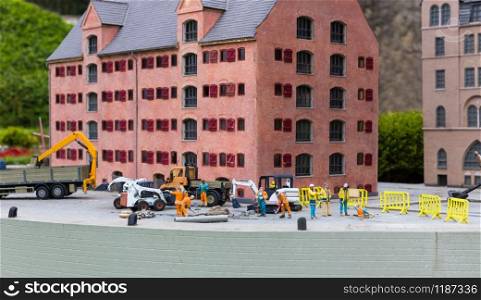 Construction site on pier, machinery and builders, miniature scene outdoor, europe. Mini figures with high detaling of objects, realistically diorama