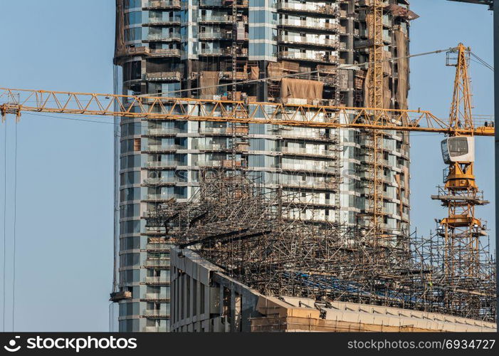 Construction site. Power plant construction. Cranes and building construction against blue sky.