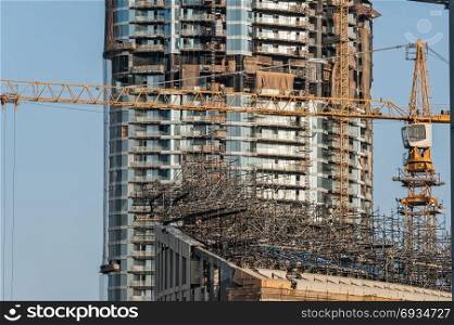 Construction site. Power plant construction. Cranes and building construction against blue sky.