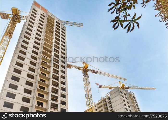 Construction site with buildings and industrial cranes