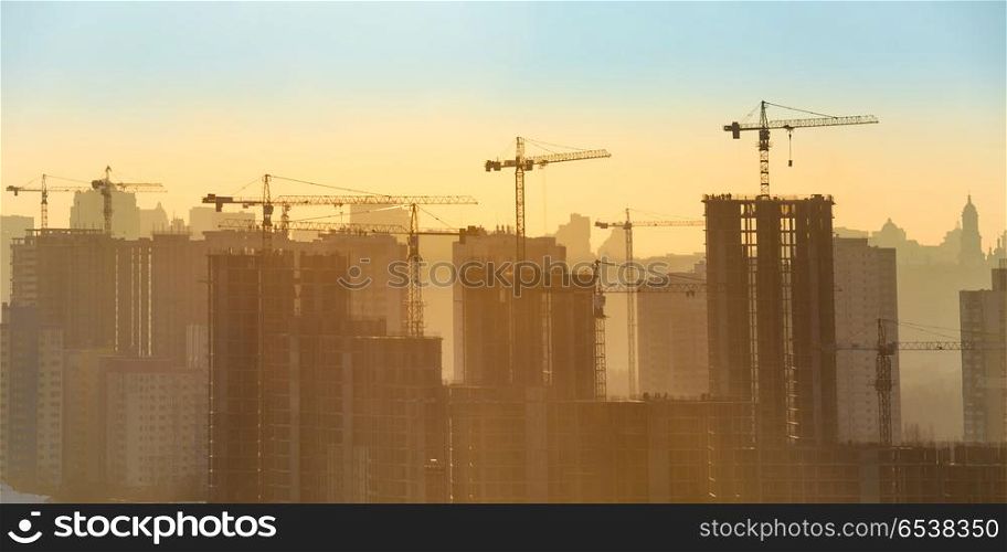 Construction site with cranes. Construction site with industrial cranes in city at sunset