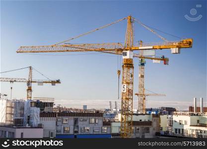 Construction site with tower cranes against clear sky.