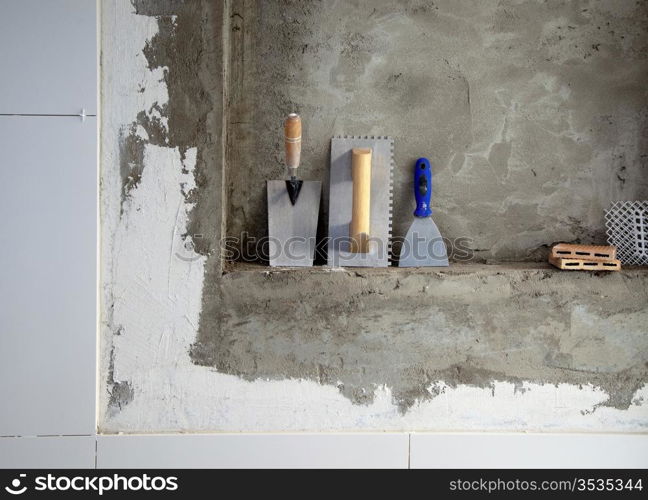 construction stainless steel trowel tools and spatula on cement mortar wall