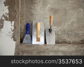 construction stainless steel trowel tools and spatula on cement mortar wall