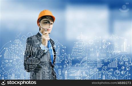 Construction strategy. Young man architect against sketch background looking in magnifying glass