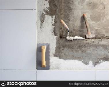construction tools notched trowel on tiles mortar wall