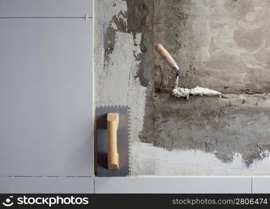 construction tools notched trowel on tiles mortar wall