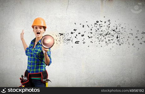 Construction worker announcing something. Young woman builder screaming emotionally in megaphone