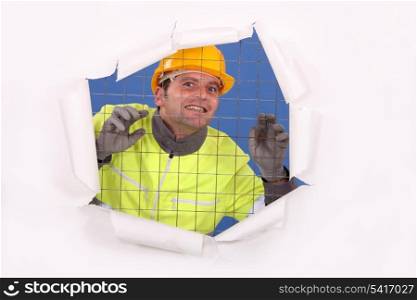 Construction worker behind wire fence