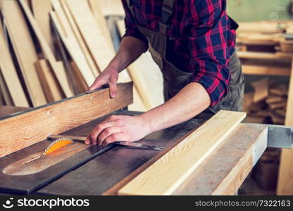 Construction worker cutting wooden board with circular saw. Construction worker cutting wooden board