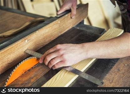 Construction worker cutting wooden board with circular saw. Construction worker cutting wooden board