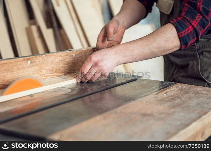 Construction worker cutting wooden board with circular saw. Construction worker cutting wooden board