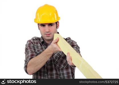 Construction worker examining a piece of wood