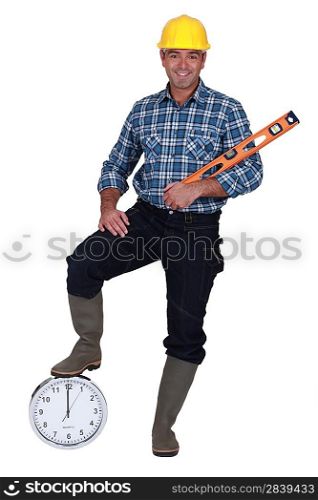 Construction worker holding a bubble level and a clock