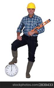 Construction worker holding a bubble level and a clock
