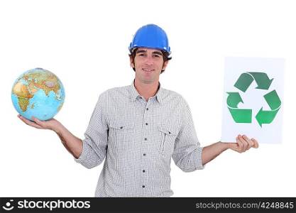 Construction worker holding a globe and recycle sign