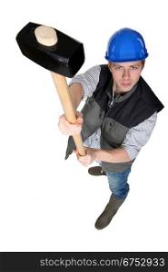 Construction worker holding a loft a sledgehammer