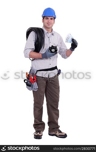 Construction worker holding a piggy bank and money