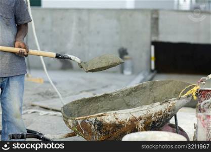 Construction worker holding a shovel with sand