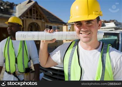 Construction worker holding blueprint, portrait