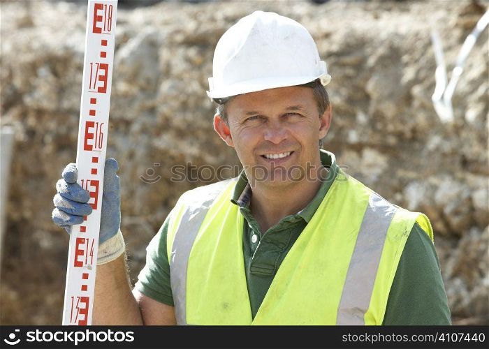Construction Worker Holding Measure