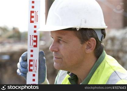 Construction Worker Holding Measure