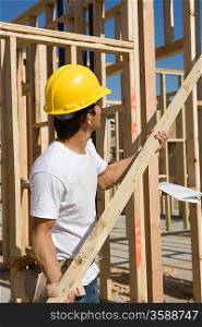 Construction worker holding plank