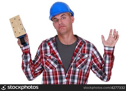 Construction worker holding up a sander
