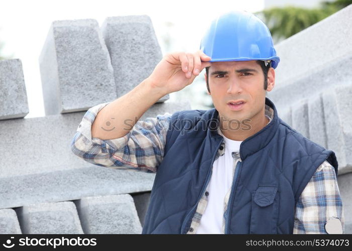 Construction worker in a hardhat next to concrete kerbing